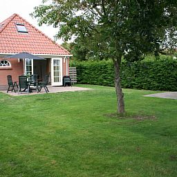 Spacious garden at D' Duinster vacation home in De Koog, Texel, surrounded by greenery on the Wadden Islands.