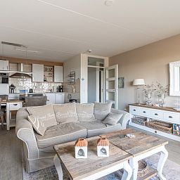 Modernes Wohnzimmer und Kueche im Apartment Juliana 116 Zeezicht, De Koog, Texel mit eleganter Einrichtung.