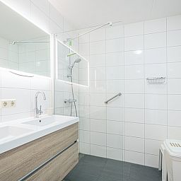 Modern bathroom of Apartment Juliana 154 Zeezicht in De Koog, Texel with double sink and spacious shower.