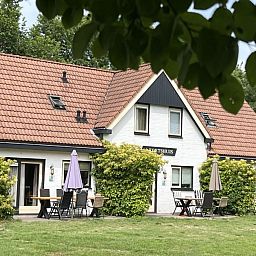 Cozy living room in Koetshuis vacation home, De Koog, Texel, with comfortable sofas and a serene atmosphere for ultimate relaxation.