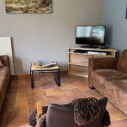 Cozy living room of Koetshuis vacation home in De Koog, Texel, with comfortable sofas and warm decor on the Wadden Islands.