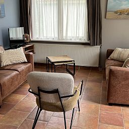 Modern kitchen in Koetshuis vacation home, De Koog, Texel, with wooden cabinets and views of green nature.