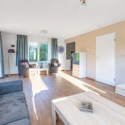 Helle Wohnraeume im Ferienhaus Honeysuckle 97, De Koog, Texel mit Blick auf den Garten der Watteninseln.