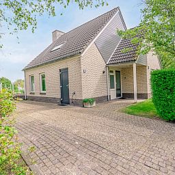 Entrance to Holiday home Honeysuckle 55 in De Koog Texel, surrounded by lush nature.