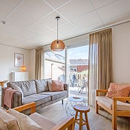 Cozy living room of De Duinroos in De Koog, Texel with comfortable sofas and lots of light.