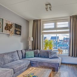 Cozy living room in De Bosruiter vacation home, De Koog Texel, with comfortable sofa and lots of natural light.