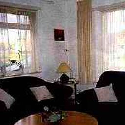 Gemtliches Wohnzimmer im Ferienhaus Brink 9, De Koog Texel, mit bequemer Sitzecke und viel Tageslicht.