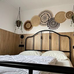 Schlafzimmer mit Doppelbett im Chalet Bregkoog 253, De Koog, Texel bietet eine gemuetliche und entspannte Atmosphaere.