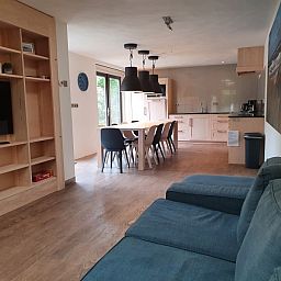 Offener Wohnbereich im Ferienhaus Orchismient 24, De Koog, Texel, mit Kueche und Sitzecke.