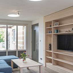 Helles Wohnzimmer in Orchismient 24, De Koog, Texel, mit grossen Fenstern und Einbauschrank.