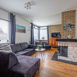 Cozy living room with fireplace in Orchismient 55 vacation home De Koog Texel.