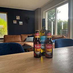Gezellige eetruimte in De Duinven, De Koog, Texel, met lokale Texelse bieren en wijn, ideaal voor avonden met vrienden.