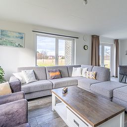 Modern living room of Holiday home Honeysuckle 67 in De Koog Texel with comfortable seating area and lots of natural light on the Wadden Islands.