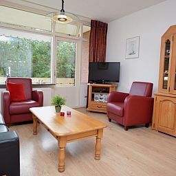 Geraeumiges Wohnzimmer der Ferienwohnung Kerckeland 110 in De Koog Texel mit Blick auf die Natur.