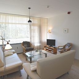 Bright living room with large windows in Apartment Kerckeland 80, De Koog, Texel, ideal for relaxation.