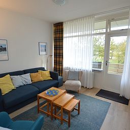 Bright living room in Apartment Kerckeland 126, De Koog, Texel, with large windows and views of nature.