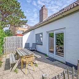 Sunny terrace with wooden seating at 32a Castor vacation home, De Koog, Texel.