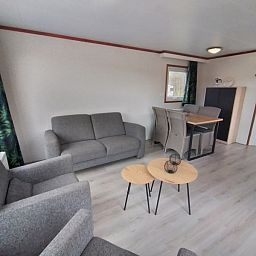 Spacious living space in Chalet Uit en Thuis, De Koog, Texel, with sitting area and dining table.
