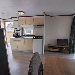 Kitchen of Chalet Uit en Thuis in De Koog, Texel, with modern appliances and open connection to the living room.