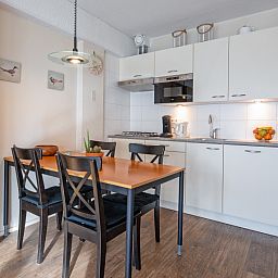 Dining area of Motel Texel Apartment with bath (B), De Koog, Texel with stylish furnishings and kitchen.
