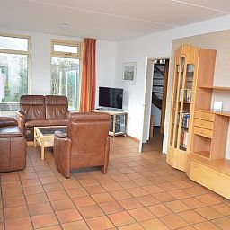 Cozy living room in Holiday home Stappeland 199, De Koog, Texel, with comfortable leather sofas and lots of natural light.
