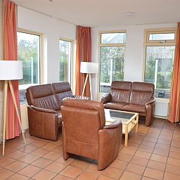 Bright sitting area in Holiday home Stappeland 199, De Koog, Texel, with modern furniture and a cozy wood stove.