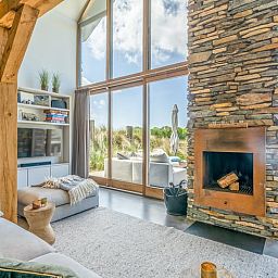 Wooden fireplace in cottage in De Koog overlooking terrace and nature.