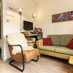 Cozy sitting area in Schanulleke, De Koog, Texel, vacation home with comfortable sofa and armchair.