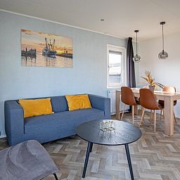 Dining area in Chalet Park Bregkoog - Chalet Bregkoog 162, Texel with wooden table and comfortable chairs for cozy meals.