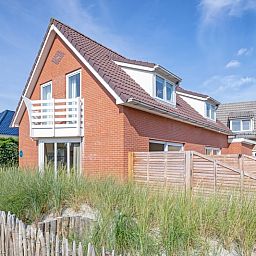 Vogelweelde vacation accommodation in De Koog, Texel with sunny garden and wooden fence.