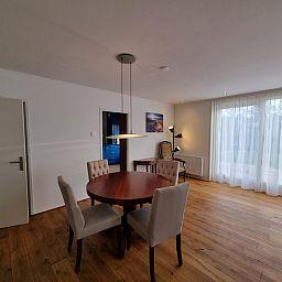 Dining room in Bungalow Epelaan 13, De Koog, Texel, with round table and stylish lighting.
