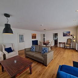 Open living space in Bungalow Epelaan 13, De Koog, Texel, with modern furniture and wooden floor.