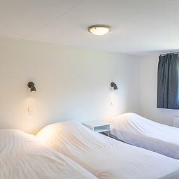 Geraeumiges Schlafzimmer im Bungalow 1, De Koog, Texel mit drei Einzelbetten, ideal fuer Familien.