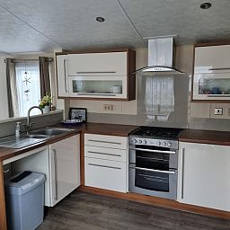 Modern kitchen in Chalet Bregkoog 16 Zanderij, De Koog Texel, complete with stove and wooden worktop.