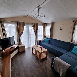 Chalet Bregkoog 16 Zanderij, De Koog Texel, living room with flat-screen TV and cozy furnishings.