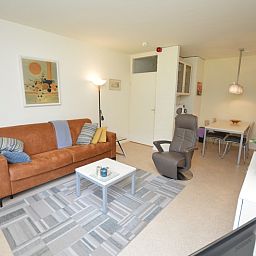 Gemuetliche Sitzecke im Apartment Kerckeland 64, De Koog, Texel, mit modernen Moebeln und warmen Farben.