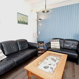 Comfortable seating area in Motel Texel - Apartment 315/1T, De Koog, Texel with leather sofas and a rustic coffee table.