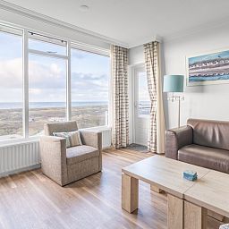 Lichte woonkamer met grote ramen en uitzicht op zee in Appartement Juliana 164 Zeezicht, De Koog.