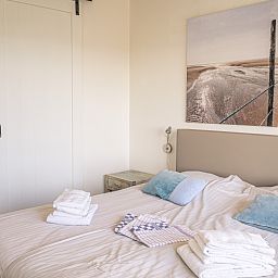 Gemuetliches Schlafzimmer mit Kunst an der Wand im Appartement Juliana 172 Eilandzicht, De Koog Texel, perfekt fuer einen entspannten Aufenthalt.