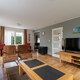 Modern living room in Holiday home Honeysuckle 43 with sauna, De Koog, Texel, with spacious windows and comfortable furniture.