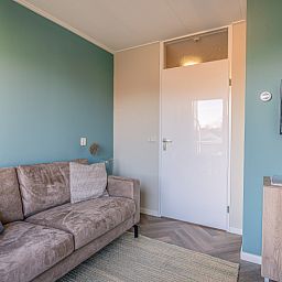 Modern furnished living room with TV in Apartment Zeedistel 24, De Koog, Texel.