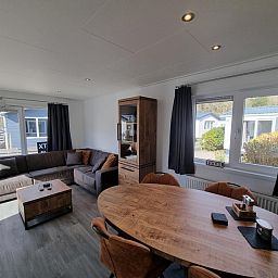 Chaletpark Bregkoog - Chalet 45 TX45 in De Koog, Texel, gemuetliches Wohnzimmer mit Ecksofa und Essecke.