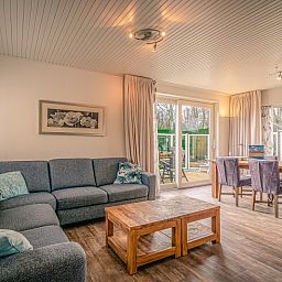 Spacious living room of Orchismient 2, vacation home in De Koog, Texel with comfortable sofa and dining area.