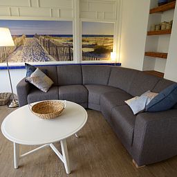 Comfortable sitting area in Grand Hotel Opduin - Holiday home C, De Koog, Texel, with attractive decorations and beach picture.