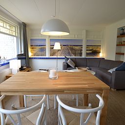 Spacious dining room in Grand Hotel Opduin - Holiday home C, De Koog, Texel, with wooden table and cozy living room.