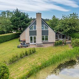 View of Holiday home Honeysuckle 71 in De Koog, Texel with green surroundings.