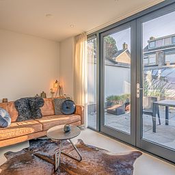 Cozy living room in vacation home Het Bospad - Brink 15, De Koog, Texel. Comfortable sofa and lots of natural light.