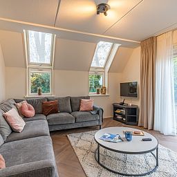Gezellige woonkamer van Landhuis Het Oude Dijkje, vakantiewoning in De Koog, Texel, met comfortabele zithoek.