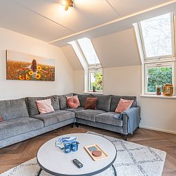 Ruime woonkamer in Landhuis Het Oude Dijkje, De Koog, Texel, met veel natuurlijk licht en uitzicht op de tuin.