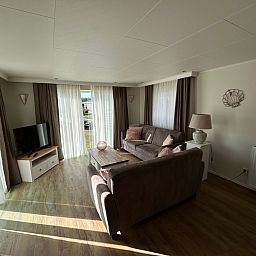 Helles Wohnzimmer im Chalet Bregkoog 213, Chaletpark Bregkoog, De Koog Texel, mit Blick auf den Garten.